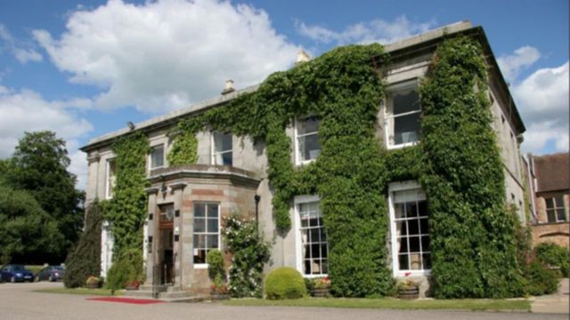 A large house covered in greenery